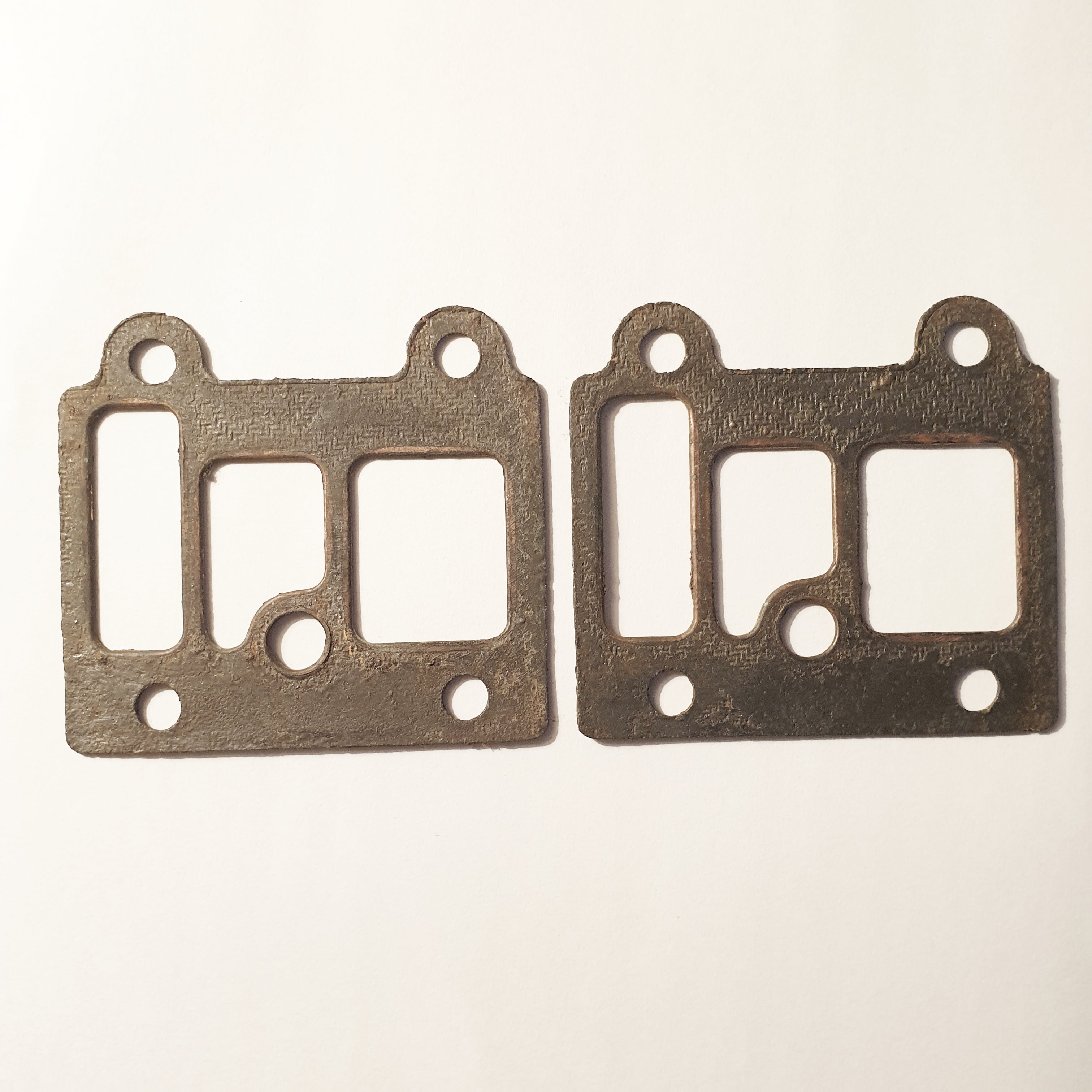 Two metallic gaskets on a beige background